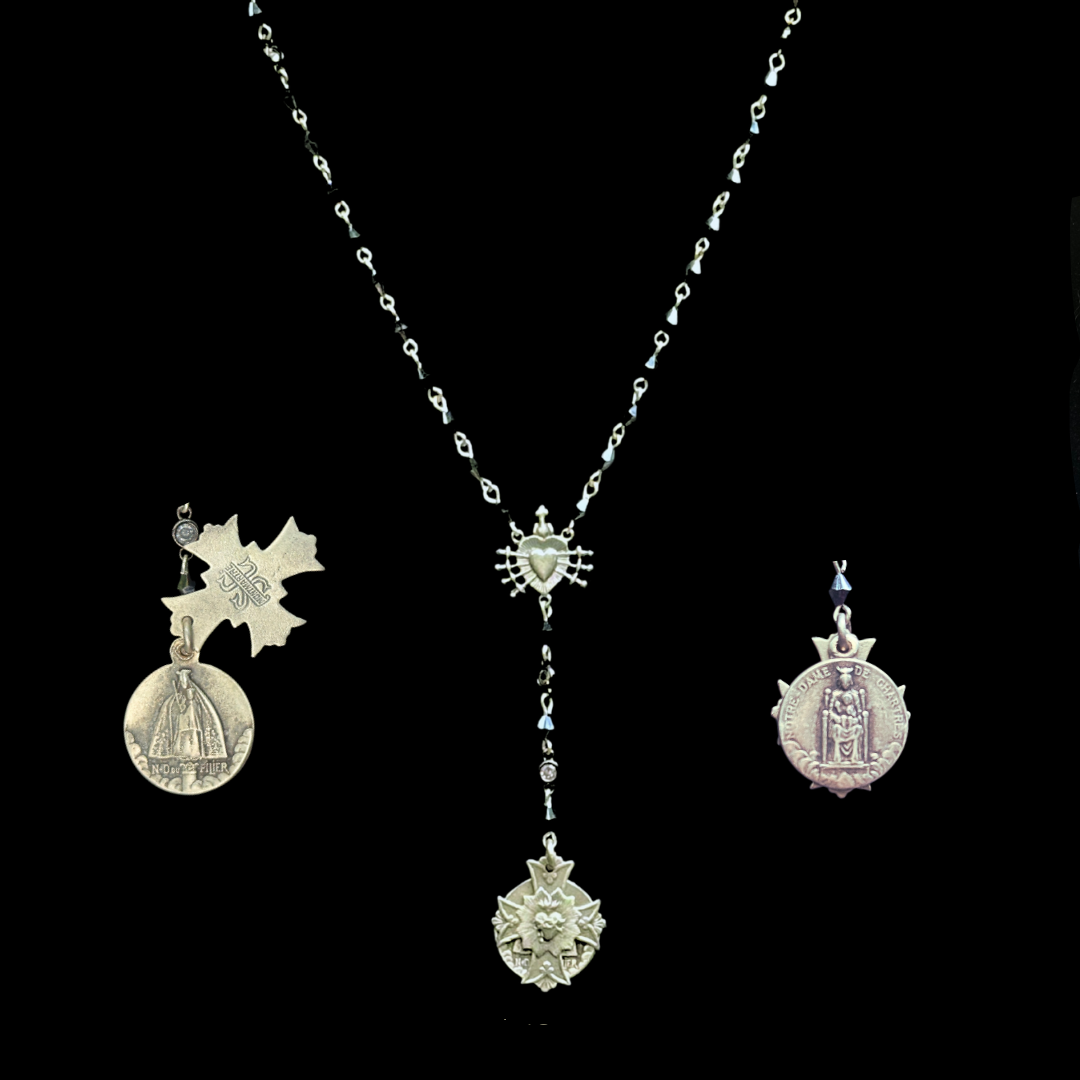 Silver rosary set with medals on a black background, featuring the Black Madonnas of Chartres